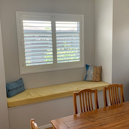 Shutters frame this lovely window seat and add elegance to dining